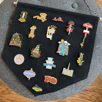 Collection of colorful Las Vegas-themed pins on a black background